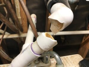 Busted PVC water pipe with ice frozen and water dripping