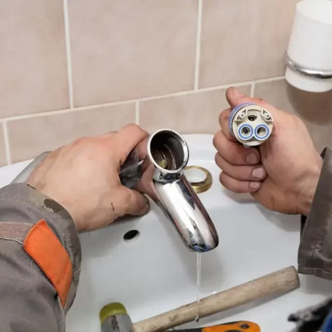 Plumber Repairing the Faucet of a Sink